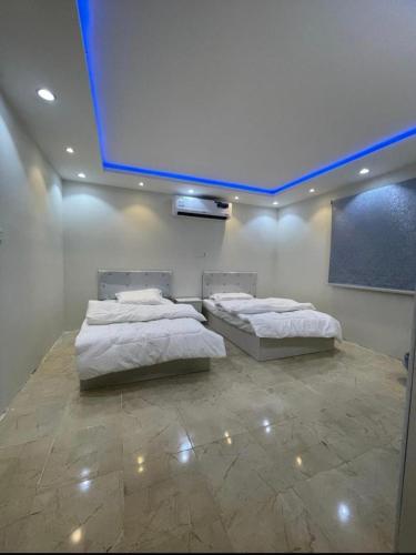 two beds in a room with a projection screen at استراحه كيان in AlUla