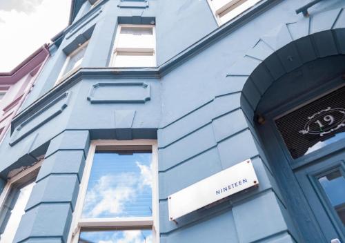 a blue building with a reflection of the sky in a window at Hotel Nineteen in Brighton & Hove