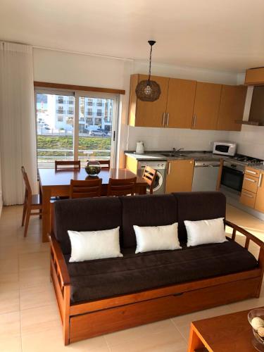 a living room with a couch and a kitchen at Alojamentos Campo & Mar - T1 com Piscina in São Martinho do Porto