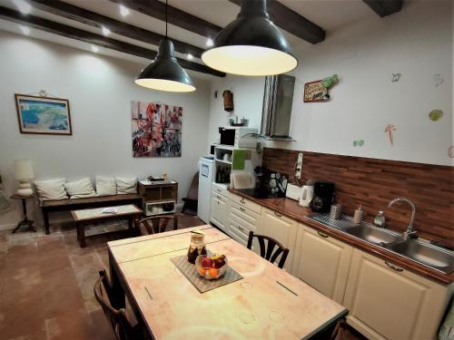 a kitchen with a wooden table and a sink at Moissac - La coquille à deux pas de l'Abbaye in Moissac