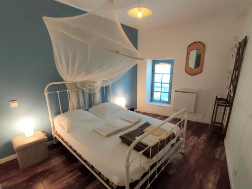 ein Schlafzimmer mit einem weißen Bett mit Baldachin in der Unterkunft Moissac - La coquille à deux pas de l'Abbaye in Moissac