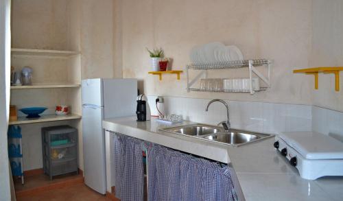 una cucina con lavandino e frigorifero di Maison Bellevue ad Alcamo Marina