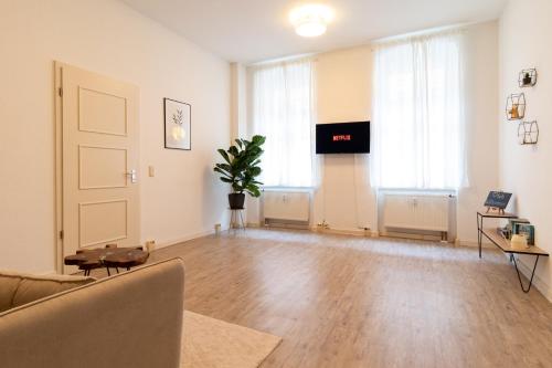 uma sala de estar com um sofá e uma televisão de ecrã plano em Exklusive Wohnung mit Kingsize-Bett I 75qm I am See I Netflix I gratis Kaffee & Teeangebot em Chemnitz
