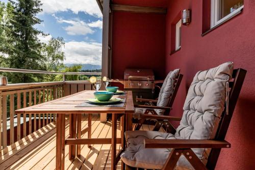 a deck with a wooden table and two chairs at Tom's Seeblick Domizil in Unternarrach