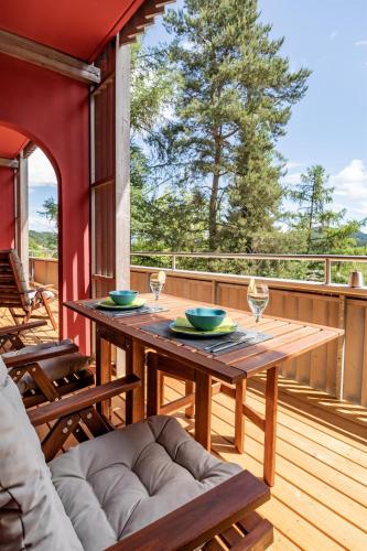 a wooden table on the deck of a house at Tom's Seeblick Domizil in Unternarrach