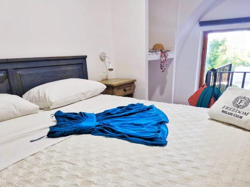 a blue shirt sitting on top of a bed at Hotel & Spa Relais Freedom Club in Massa Lubrense