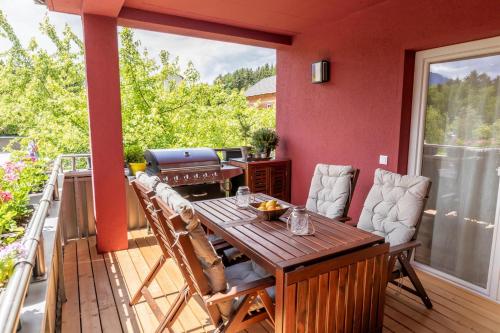a deck with a wooden table and chairs on a balcony at Anja's Feriendomizil in Unternarrach