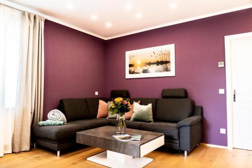 a purple living room with a couch and a table at Anja's Feriendomizil in Unternarrach
