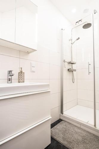 a white bathroom with a glass shower stall at Anja's Feriendomizil in Unternarrach