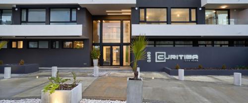 a building with a palm tree in front of it at Curitiba VIP Studio 21 in Temuco