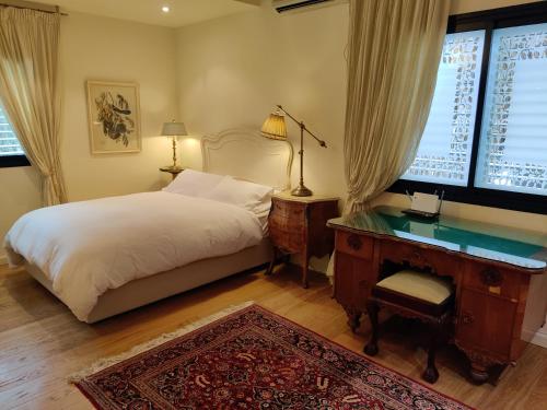 a bedroom with a bed and a desk and a window at Yarden Deluxe Studio Suite in Tel Aviv