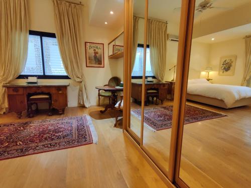 a bedroom with a bed and a desk and a mirror at Yarden Deluxe Studio Suite in Tel Aviv