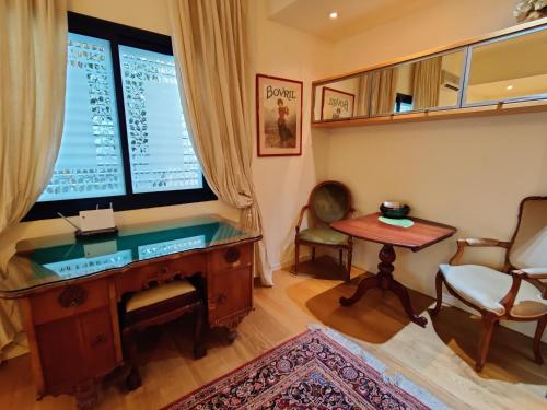 a room with a desk and a chair and a window at Yarden Deluxe Studio Suite in Tel Aviv