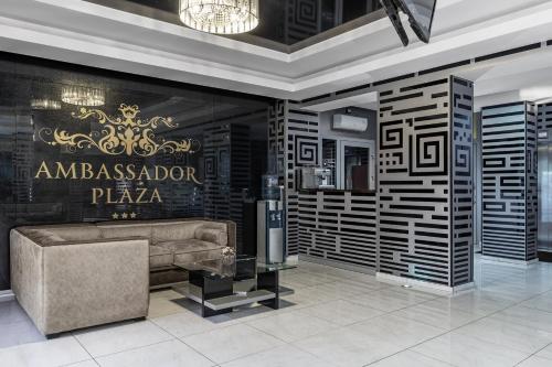 a luxury lobby with a couch and a sign on the wall at Ambassador Plaza in Kyiv