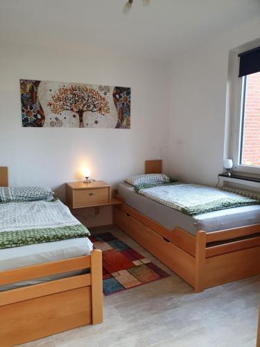 two twin beds in a room with a window at Ferienhaus Ursel in Otterndorf in Otterndorf