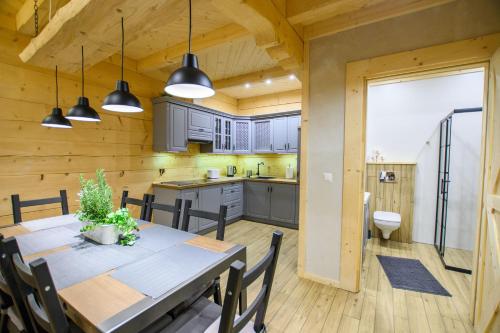 a kitchen and dining room with a table and chairs at Domki na Głodówce in Bukowina Tatrzańska