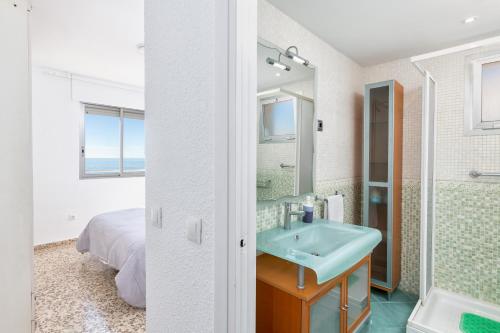 La salle de bains est pourvue d'un lavabo, d'une douche et d'un lit. dans l'établissement Amazing Sea View Apartment and Relax Area, à Rincón de la Victoria