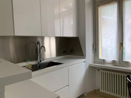 a white kitchen with a sink and a window at dolce vita in Biasca