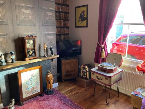 a living room with a table and a tv at Bedford House Retreat in Scarborough