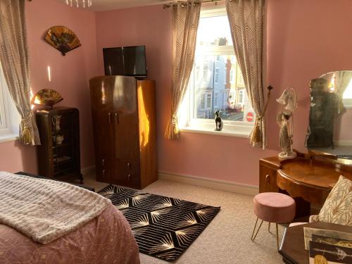a bedroom with a bed and a desk and a window at Bedford House Retreat in Scarborough