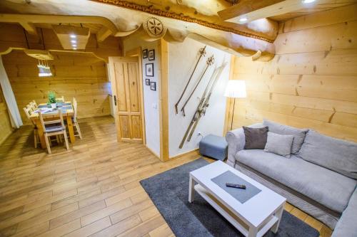 ein Wohnzimmer mit einem Sofa und einem Tisch in der Unterkunft Domki na Głodówce in Bukowina Tatrzańska