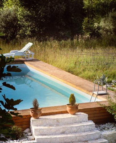 a pool with a deck and a chair in a yard at Al Passo di Thalia in Ricadi