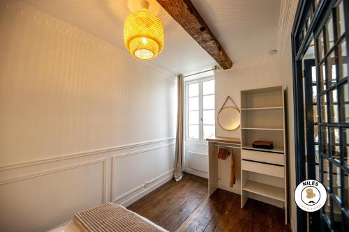 an empty room with a window and a mirror at L'Haussmann, Rare, Appartement Vue Château et Palmiers in Pau