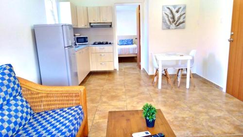 sala de estar con sofá, mesa y cocina en Rooi Santo Residence, en Palm-Eagle Beach