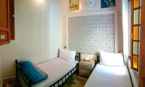 a small room with two beds and a window at Riad Fes Touria Palace in Fès