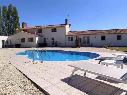 une piscine avec un banc devant une maison dans l'établissement B&B Le Bois Berranger, à Saint-Urbain
