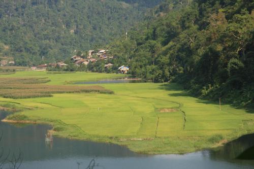 a golf course on a hill next to a body of water at Ba Be Lake View Homestay in An Ma