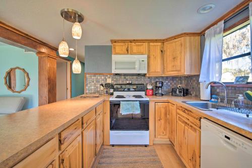 a kitchen with wooden cabinets and a stove top oven at Riverfront Apt with Kayak Launch in Dunnellon in Dunnellon