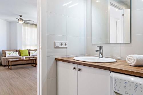 een badkamer met een wastafel en een spiegel bij Dubamar apartments in Aguadulce
