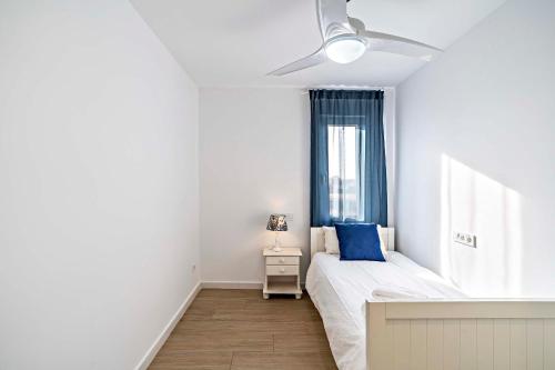 een witte slaapkamer met een bed en een raam bij Dubamar apartments in Aguadulce