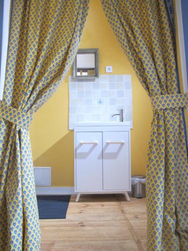 uma casa de banho com um lavatório e um espelho em poppy chambres d'hotes em Tursac