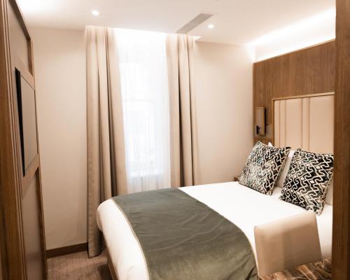 Ένα ή περισσότερα κρεβάτια σε δωμάτιο στο Merit Kensington Hotel