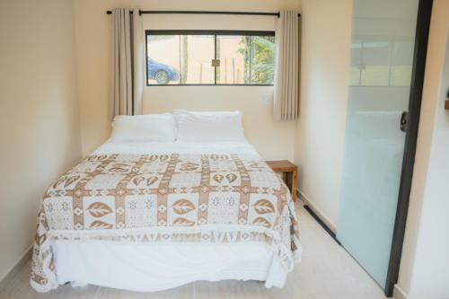 a bedroom with a bed and a window at Diver Village Ilhabela in Ilhabela
