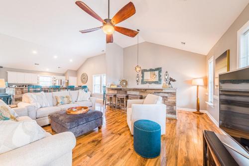 a living room with white furniture and a ceiling fan at Gone With the Wind in Duck