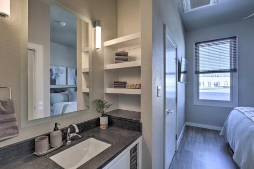 a bathroom with a sink and a bed and a mirror at Stylish San Marcos Apt in the Heart of Dwtn! in San Marcos