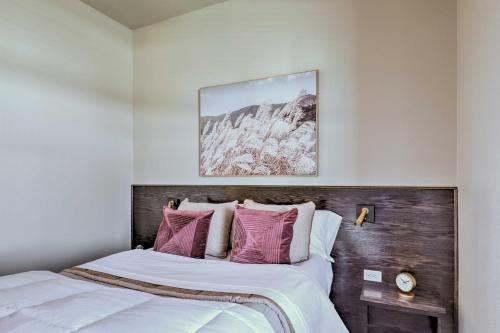 a bedroom with a bed with white and pink pillows at Stylish San Marcos Apt in the Heart of Dwtn! in San Marcos