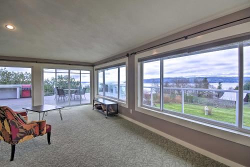 a living room with large windows and a view of the water at Breathtaking Port Ludlow Home with Deck and Yard in Port Ludlow