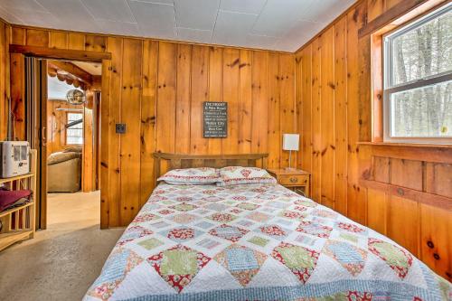 een slaapkamer met een bed met een quilt bij Remote Michigan Retreat on 10 Acres with Grill! in Irons