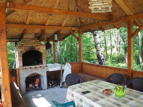 an outdoor dining area with a fireplace in a house at CASA VISTISOARA in Viştea de Sus
