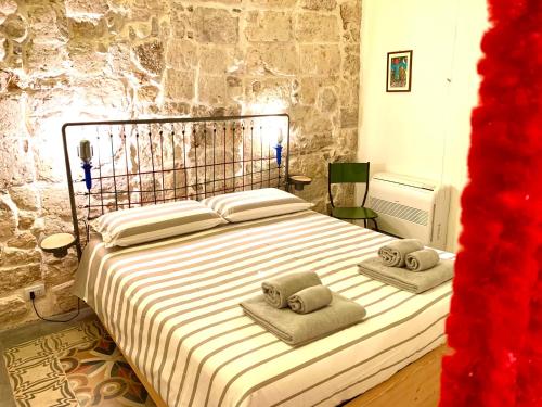 1 dormitorio con 1 cama con 2 toallas en L'Officina, en Bari