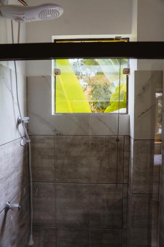 a shower with a glass door and a window at Diver Village Ilhabela in Ilhabela
