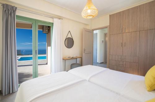 a bedroom with a bed and a view of the ocean at Villa Freya - Melisou Villas in Kalamitsi