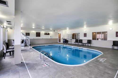 a pool in the middle of a room with tables and chairs at Comfort Suites Lincoln North in Lincoln