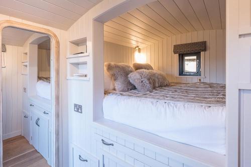 a bedroom with a bed with a large mirror at Bo Peep Shepherds Hut Thorpeness Air Manage Suffolk in Leiston