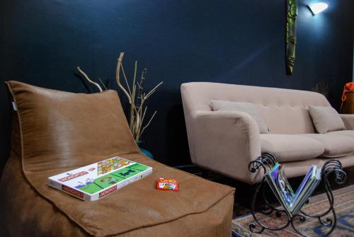 a living room with a couch and a box on a chair at The Bearded Dad Hostel in Tirana