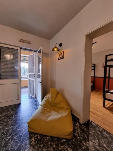a living room with a yellow bean bag chair in it at The Bearded Dad Hostel in Tirana